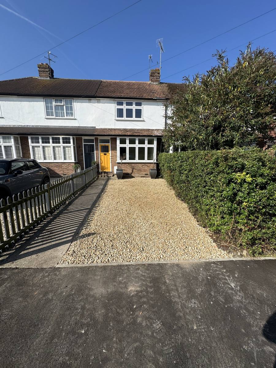 New gravel driveway leading up to a white rendered house