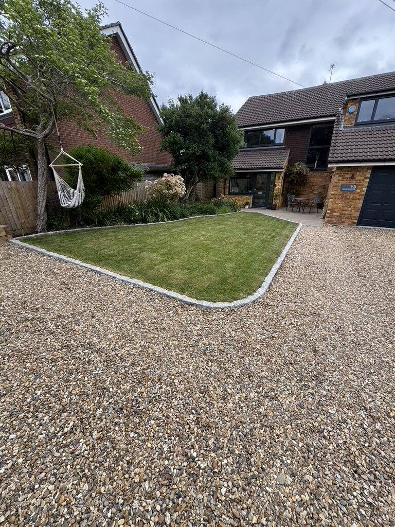Gravel driveway curving past a lawn with a clean cut edge
