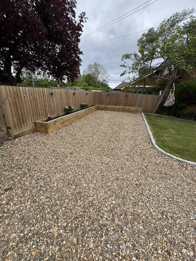 Gravel driveway edged with timber sleepers beside a lawn
