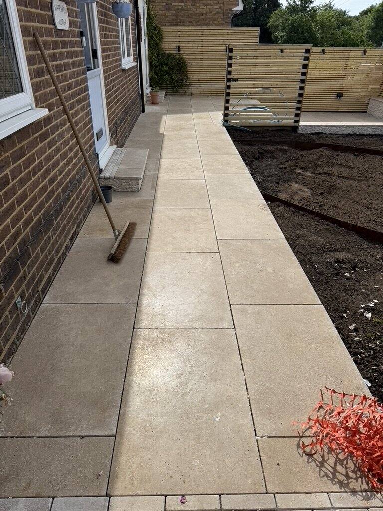 Newly laid limestone path along a house with bare soil either side