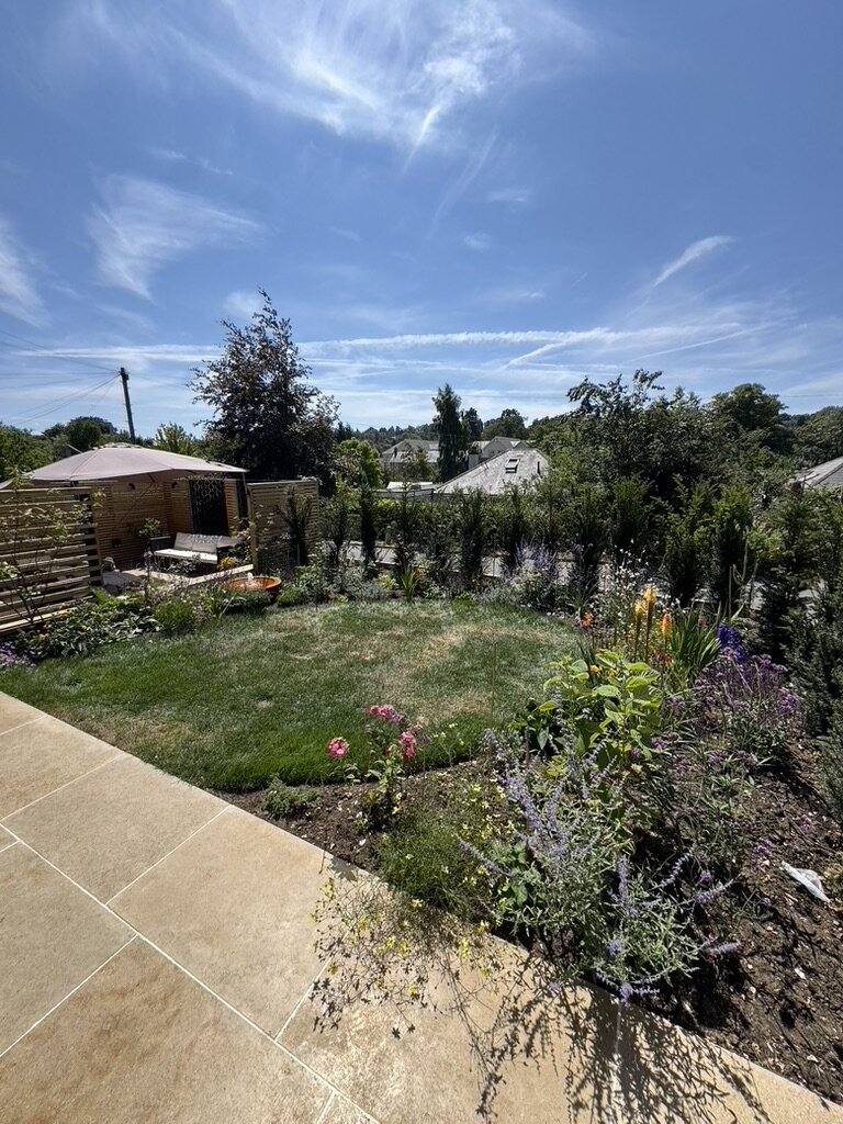 Limestone terrace edge with a deep planted border and lawn beyond