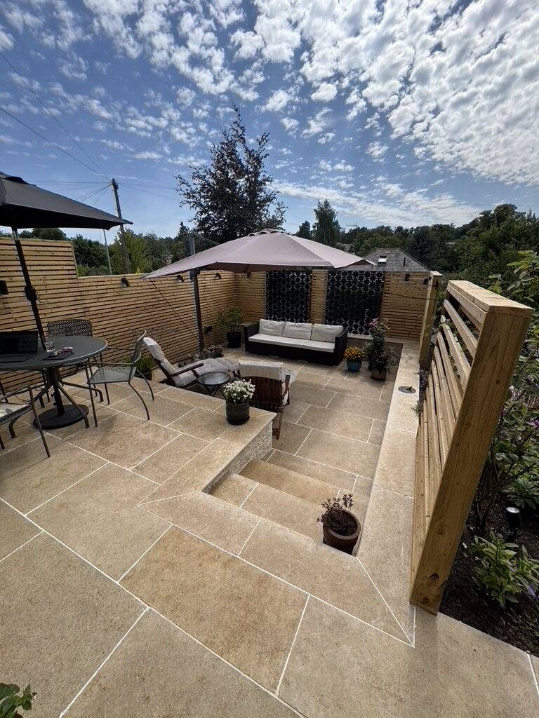 Limestone terrace with garden furniture looking out over trees and rooftops