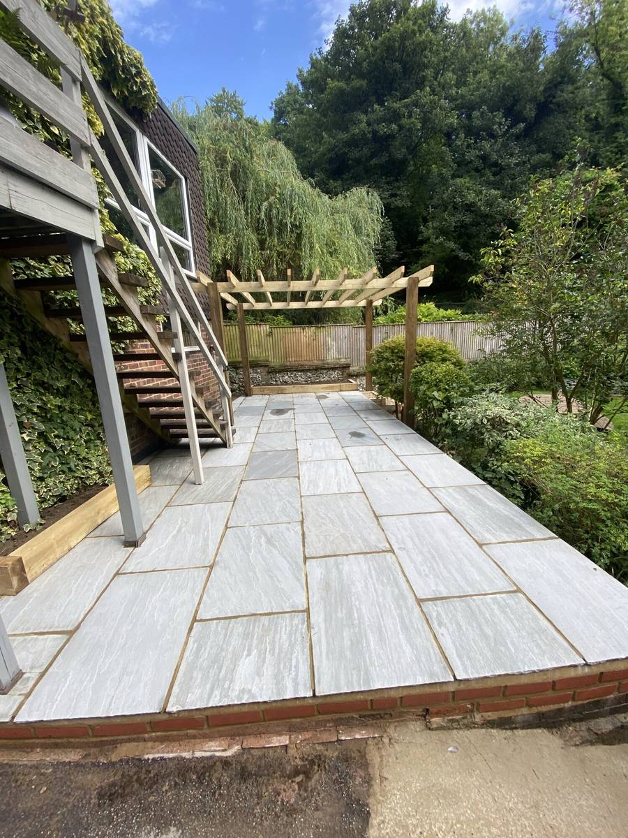 Finished porcelain terrace with sleeper edging below a raised timber deck